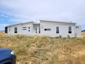 a white building in the middle of a field at Whispering Winds in Wauraltee