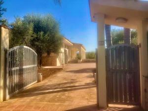 een ingang naar een huis met een witte poort bij Dimora Zizzi in Fasano