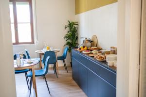 a kitchen with blue chairs and a counter with food on it at Letizia B&B in Crotone