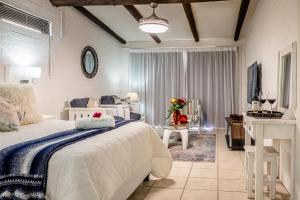 a bedroom with a large white bed and a table at Sea Villa Vista in St. Helena Bay
