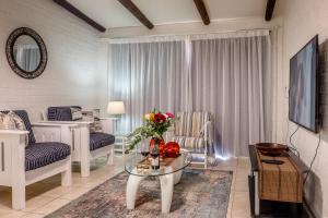 a living room with a table with a vase of flowers at Sea Villa Vista in St. Helena Bay
