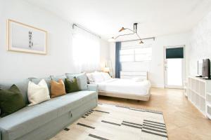 een woonkamer met een bank en een bed bij Spacious Apt in the heart of South Beach in Miami Beach