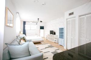 een witte woonkamer met een bank en een bed bij Spacious Apt in the heart of South Beach in Miami Beach
