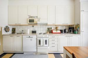 a white kitchen with white cabinets and a stove at Mäntylinnan Huoneistomajoitus in Mänttä