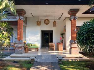 a porch of a house with a green couch at Puri Amartha in Ubud