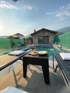 a table with food on it next to a swimming pool at Luxury Stone House With Turkish Hamam, Sauna, İndoor and Outdoor Pool in Fethiye in Mugla