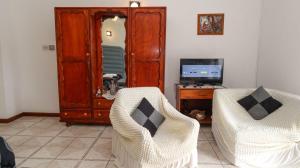 a living room with two chairs and a desk at Mountain Apartments in Anse Etoile