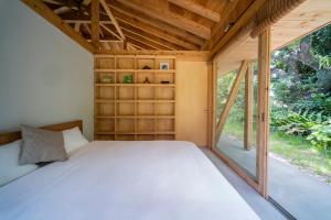 本部町にあるSHINMINKA Villa GUSHIKENの大きな窓が備わる小さな家の中のベッドルーム1室です。 +33枚の写真