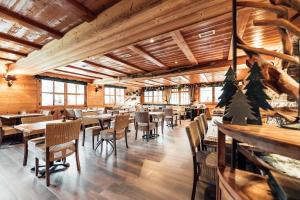 a restaurant with wooden ceilings and tables and chairs at Chalet Hôtel du Mont-Charvin & Spa in Crest-Voland