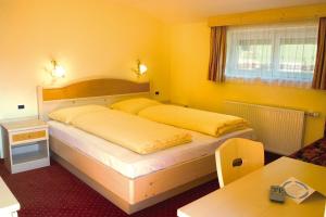 Hotel Bruggerwirt في أنتيرسيلفا دي ميزو: غرفة نوم بسريرين في غرفة صفراء