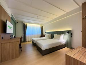 a hotel room with a bed and a desk at Shahzan Inn Fraser's Hill in Bukit Fraser