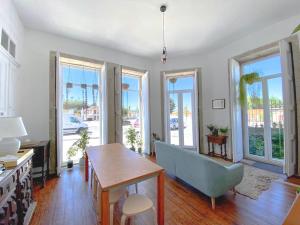 a living room with a table and a blue couch at Casa dos Caminhos de Santiago in Mosteiró