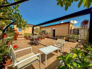 un patio con sedie, tavolo e sedie di B&B Pellicano Guest House a Reggio di Calabria