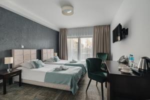 a hotel room with a bed and a desk and chair at Rewita Korab in Sopot