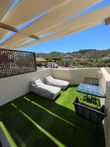 a balcony with a green carpet and a table and chairs at Skopelos Holidays Hotel & Spa in Skopelos Town