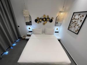 a room with two white beds and lights at Skopelos Holidays Hotel & Spa in Skopelos Town