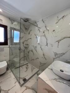 a bathroom with a glass shower and a sink at Skopelos Holidays Hotel & Spa in Skopelos Town