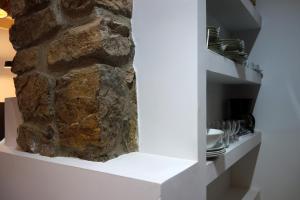 a room with a stone wall and a shelf with dishes at Belenos Alojamientos Turísticos in Niembro +92 photos