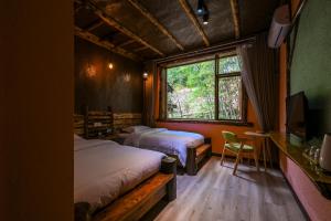 a bedroom with two beds and a tv and a window at 张家界悦庭楠舍民宿-森林公园店 in Zhangjiajie +83 photos