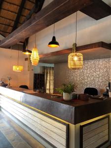 a bar in a restaurant with pendant lights at Okahandja Country Hotel in Okahandja