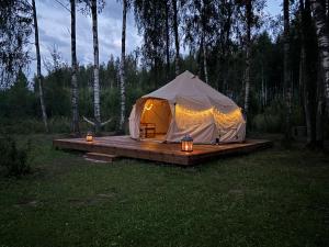a tent sitting on a wooden platform in a field at Kure talu Glämping Setomaal in Polovina