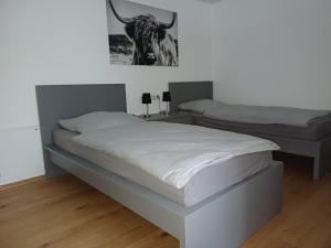ZennernWohnung 1 Tollgauer的卧室内的两张床,墙上挂着一幅公牛的照片