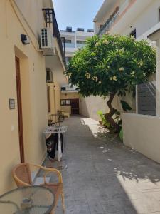 alejka ze stołem i drzewem w budynku w obiekcie Kathopouli Apartment w mieście Rodos
