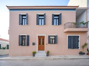 a pink house with black shutters and a door at The Alma City Hotel in Chania Town