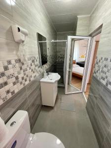 a bathroom with a toilet and a sink and a mirror at Vila Cochilia Costinesti ULTRACENTRAL 3 stele in Costinesti