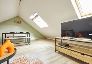 Una sala de estar con un televisor de pantalla plana grande. en Elégant T3 A 5 min de la gare Lille-Flandres, en Mons-en-Baroeul