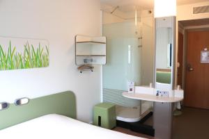 y baño con lavabo y espejo. en ibis budget Castelnaudary - A61, en Castelnaudary