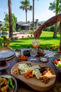 a table with food and a person pouring a drink at Kaya Villas Exclusive in Kayakoy