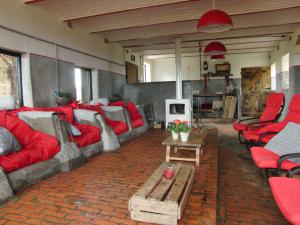 Zulzeke的住宿－'t Nophof，客厅配有红色家具和红色椅子