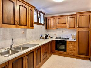 a kitchen with wooden cabinets and a sink at Appartamento Salentorelax in Salve