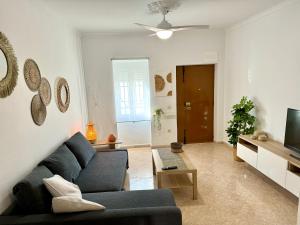 a living room with a blue couch and a tv at Vistas del Valle in Valle de Abdalagís