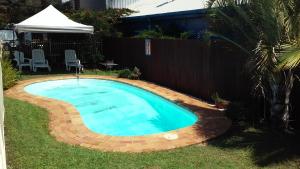 una pequeña piscina en un patio junto a una valla en Nambour Central Motel en Nambour