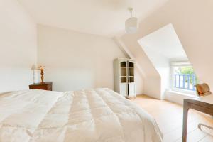 a white bedroom with a large bed and a window at Vue sur mer, maison pour 7 Golfe du Morbihan in Sarzeau