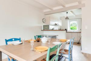a kitchen and dining room with a wooden table and chairs at Vue sur mer, maison pour 7 Golfe du Morbihan in Sarzeau