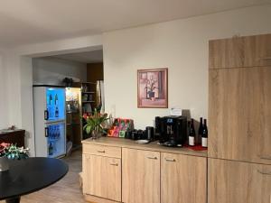 a kitchen with a counter with a refrigerator and a table at Hotel Pension Wiesenau in Bad Salzhausen