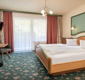 a hotel room with a large bed and a desk at Hotel Bergglück in Filzmoos