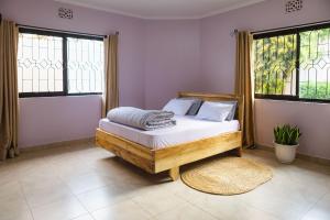 a bedroom with a bed and two windows at Kaanyi homestay in Arusha