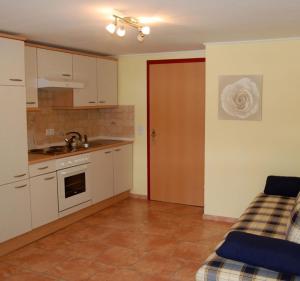 a kitchen with white cabinets and a red door at Hotel Bergglück in Filzmoos