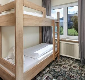 two bunk beds in a room with a window at Hotel Bergglück in Filzmoos