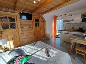 ein Schlafzimmer mit einem Bett und eine Küche in einer Hütte in der Unterkunft Sichlański Zakątek in Murzasichle