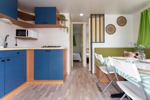 a kitchen and dining room with blue cabinets and a table at Villa Aleo solo familias in Alhaurín de la Torre +20 photos