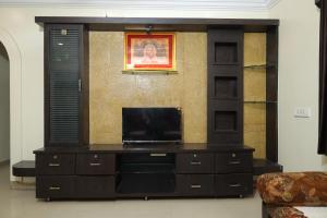 a entertainment center with a flat screen tv in a living room at Laxminarayan service apartment in Shirdi