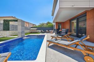a house with a swimming pool and a patio with at Villa Pavlina in Kaštela