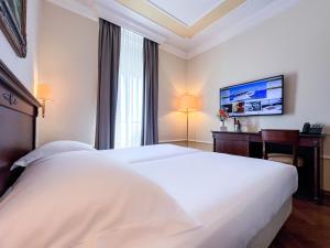 a hotel room with two white beds and a desk at Amadria Park Hotel Agava in Opatija +26 photos