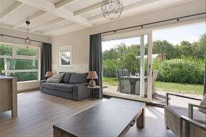 a living room with a couch and a table at Prinsenhof 13 - Ouddorp in Ouddorp