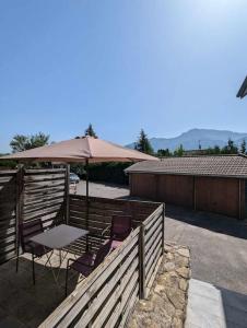 a patio with a table and chairs and an umbrella at Cabana & Studio Alpin Annecy - Terrasse Parking in Argonay